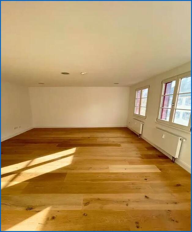 Beispiel Zimmer mit hochwertigen Holzdielen und indirekter Beleuchtung durch Spots Mehrfamilienhaus �berlingen